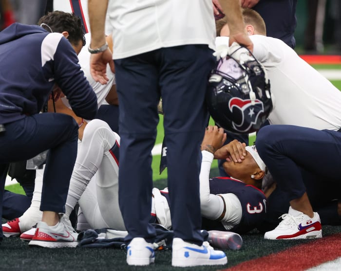 Trainers work on an injured Houston Texans wide receiver Tank Dell as he injured himself on a touchdown play against the Denver Broncos at NRG Stadium.